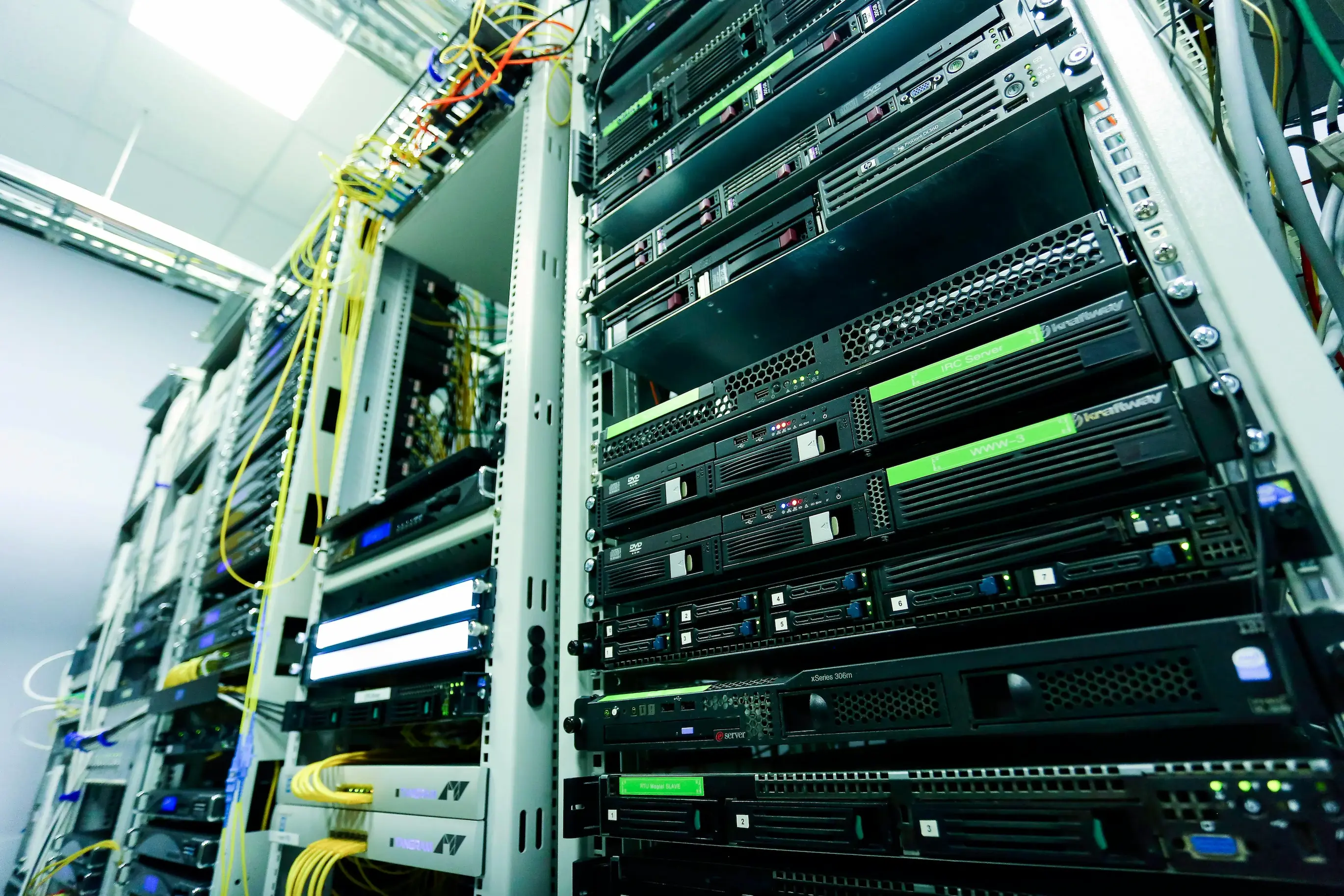 Data centre server rack with yellow and green fiber optic cables — factory-direct G.657.A2 fiber supply to European data centres