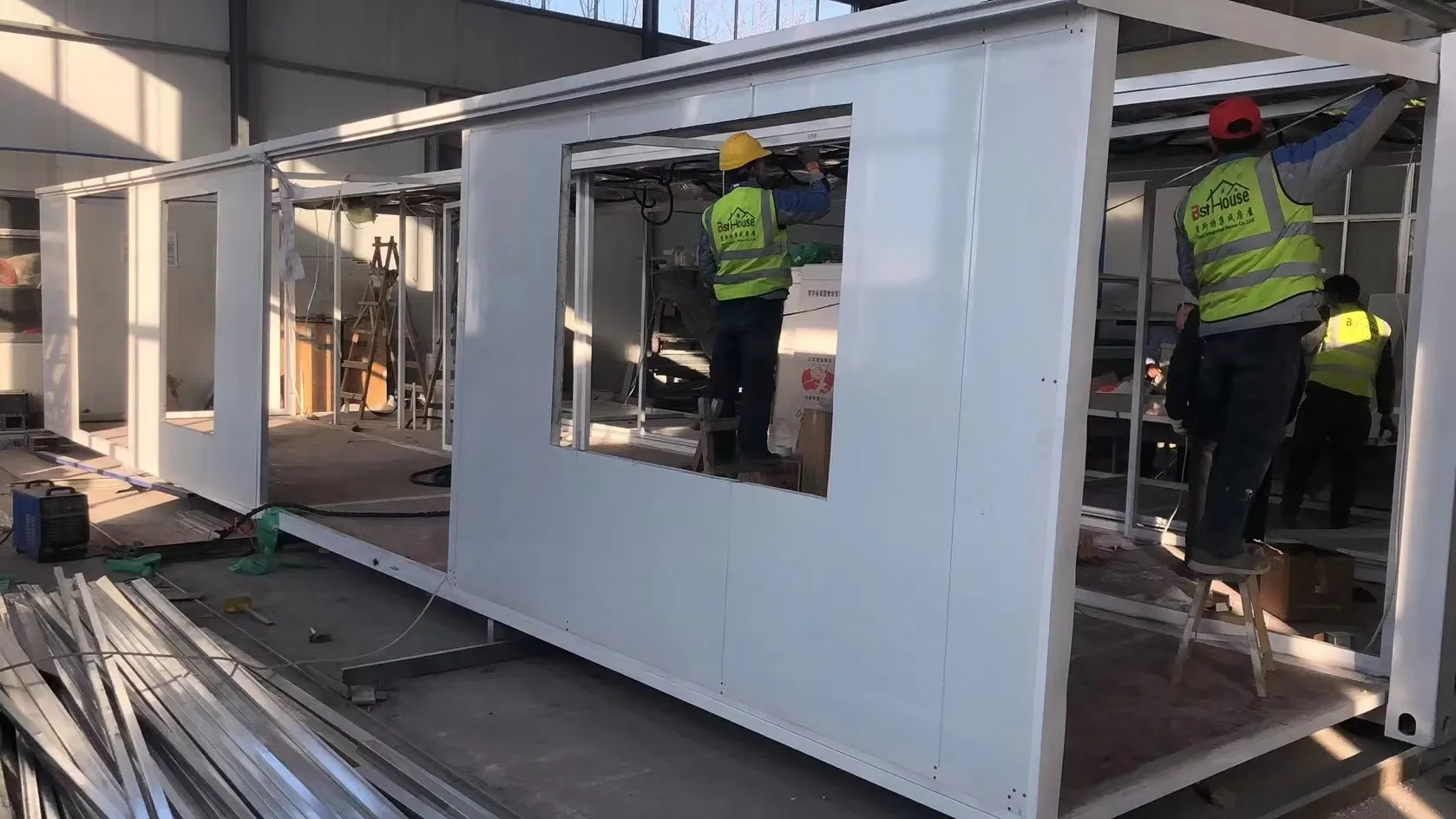 Workers assembling modular building units on a Henan factory floor, the kind of supplier Ériu Sourcing audits and works with