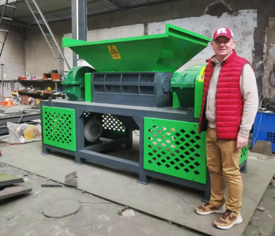 Ériu's Noel beside the green industrial mattress shredder at the manufacturer's factory in Henan, China
