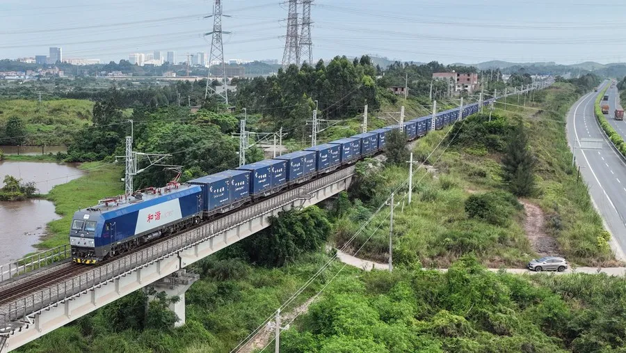 A container freight train hauling stacked containers across a viaduct, China–Europe rail of the kind routed from Zhengzhou